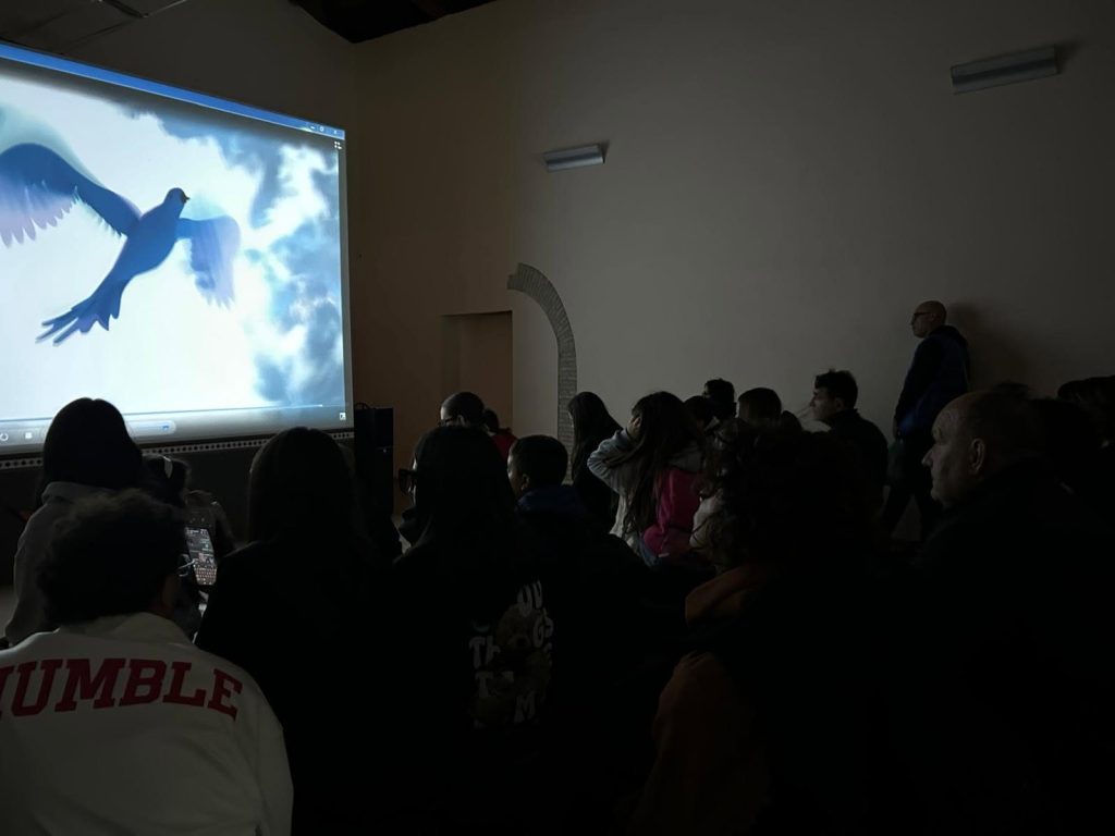 Visitatori davanti a un racconto multimediale con l'uccellino blu della ceramica calvellese
