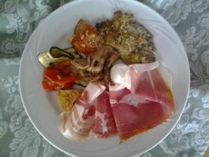 Un piatto di antipasti con salumi e verdure del ristorante dell'Albergo Volturino