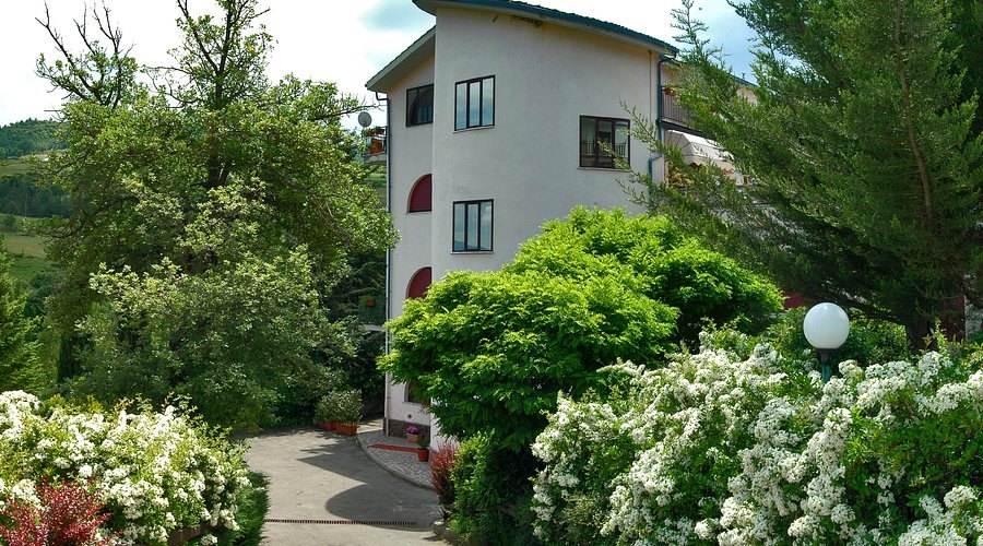 L'Albergo Volturino a Calvello, immerso nel verde tra alberi e cespugli fioriti