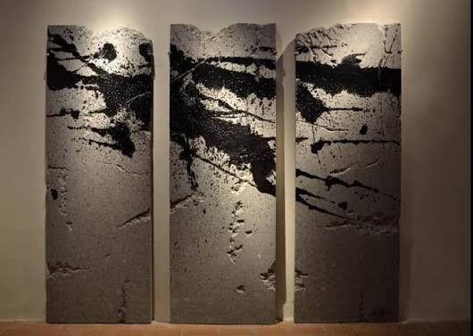 Spalle al muro, opera di Tony Rotunno: tre lastre di pietra chiara segnate da colature scure