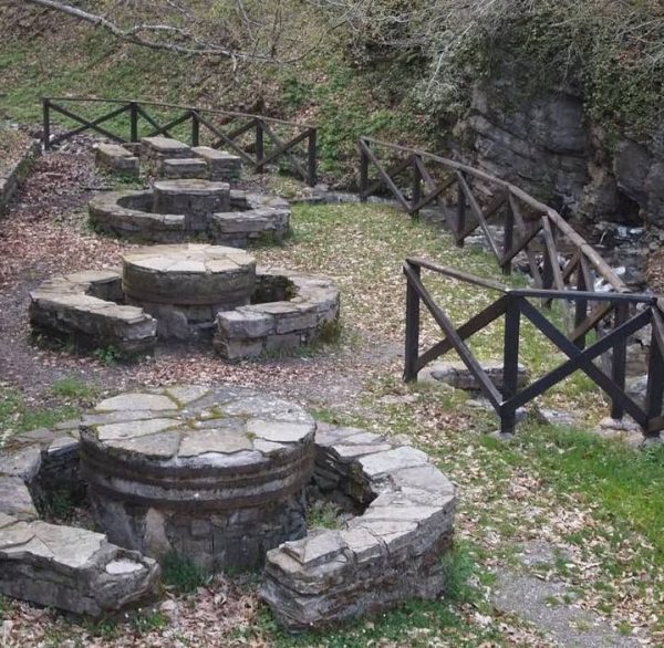 Antiche strutture in pietra lungo un sentiero nel verde