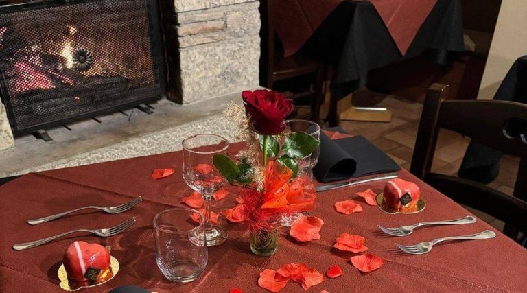 Tavola apparecchiata accanto al camino acceso nella Trattoria Al Vecchio Mulino