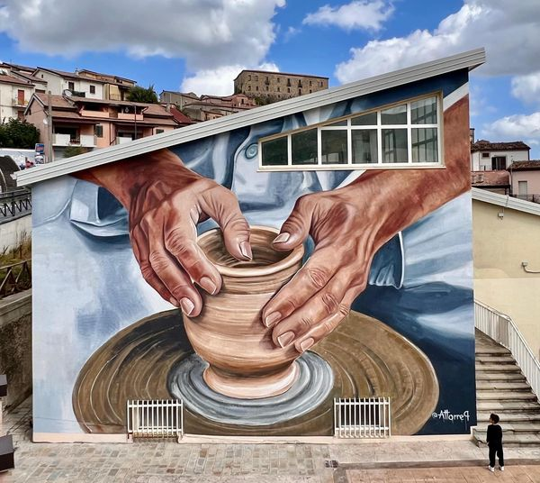 Le mani di un artigiano al lavoro sul tornio, tradizione della ceramica calvellese