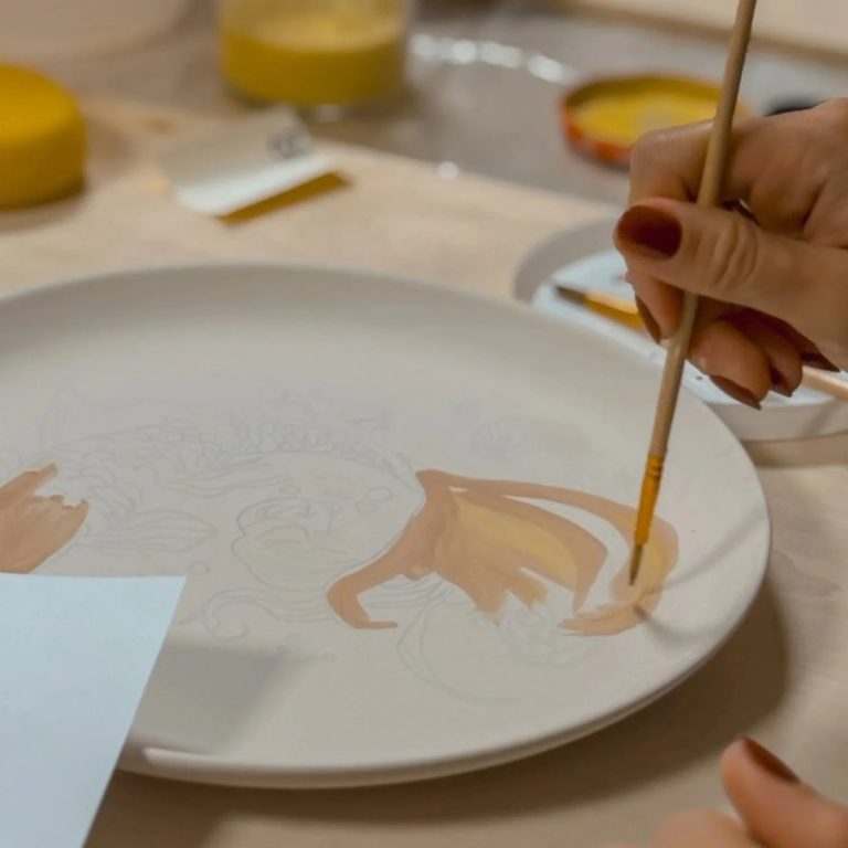 Mano che decora un piatto a pennello