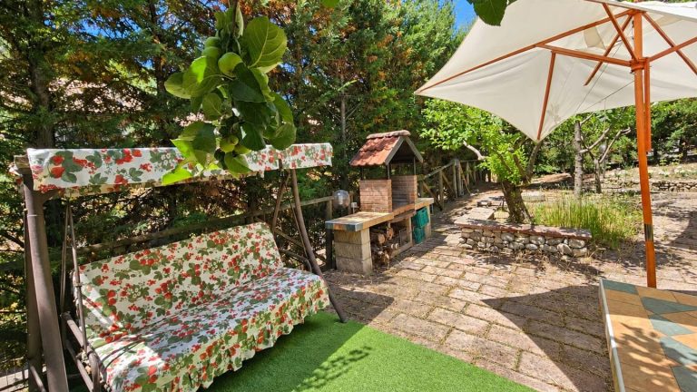Giardino della casa vacanze a Calvello con dondolo, barbecue in muratura e ombrellone
